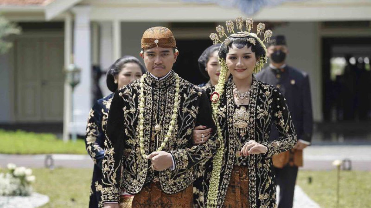 Putra bungsu Presiden Joko Widodo, Kaesang Pangarep (kiri) bersama istrinya Erina Gudono (kanan) berjalan menuju lokasi resepsi Tasyakuran di Pura Mangkunegaran, Solo, Jawa Tengah, Minggu (11/12/2022). Acara Tasyakuran itu dibagi menjadi dua sesi, yakni pagi hingga siang dan sore hingga malam untuk menyambut tamu undangan, baik dari kedua mempelai, besan ataupun tamu kenegaraan. ANTARA FOTO/Dhemas Reviyanto/wsj.