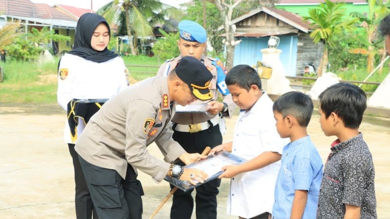 Kepala Polresta Banjarmasin, Komisaris Besar Polisi Sabana Atmojo, memberikan penghargaan untuk tiga bocah yang telah berhasil menggagalkan upaya pencurian ponsel, Selasa (20/12/2022). ANTARA/Firman