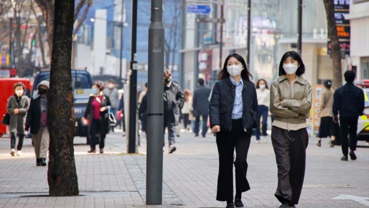 Arsip - Warga sambil memakai masker berjalan di distrik perbelanjaan di tengah pandemi COVID-19 di Seoul, Korea Selatan, 16 Maret 2022. (ANTARA/Reuters/Heo Ran/as)