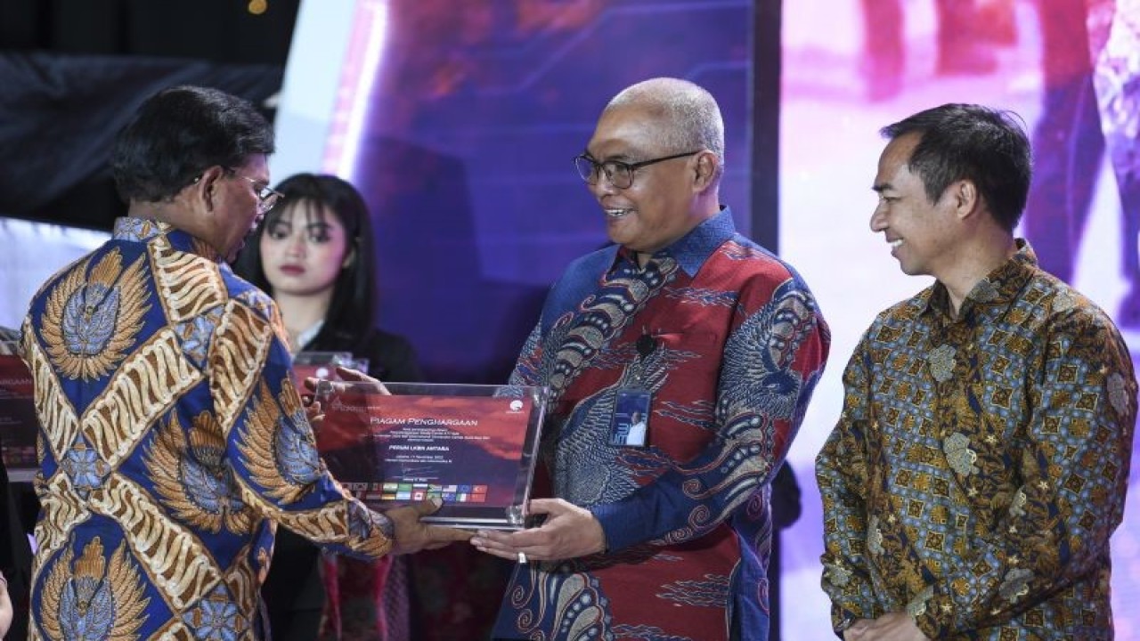 Menteri Komunikasi dan Informatika Johnny G. Plate (kiri) memberikan piagam penghargaan Apresiasi Tim Komunikasi Publik dan Media Presidensi G20 kepada Direktur Pemberitaan Perum LKBN Antara Akhmad Munir (kedua kanan) di Jakarta, Selasa (20/12/2022). ANTARA FOTO/M Risyal Hidayat/aww (ANTARA FOTO/M RISYAL HIDAYAT)