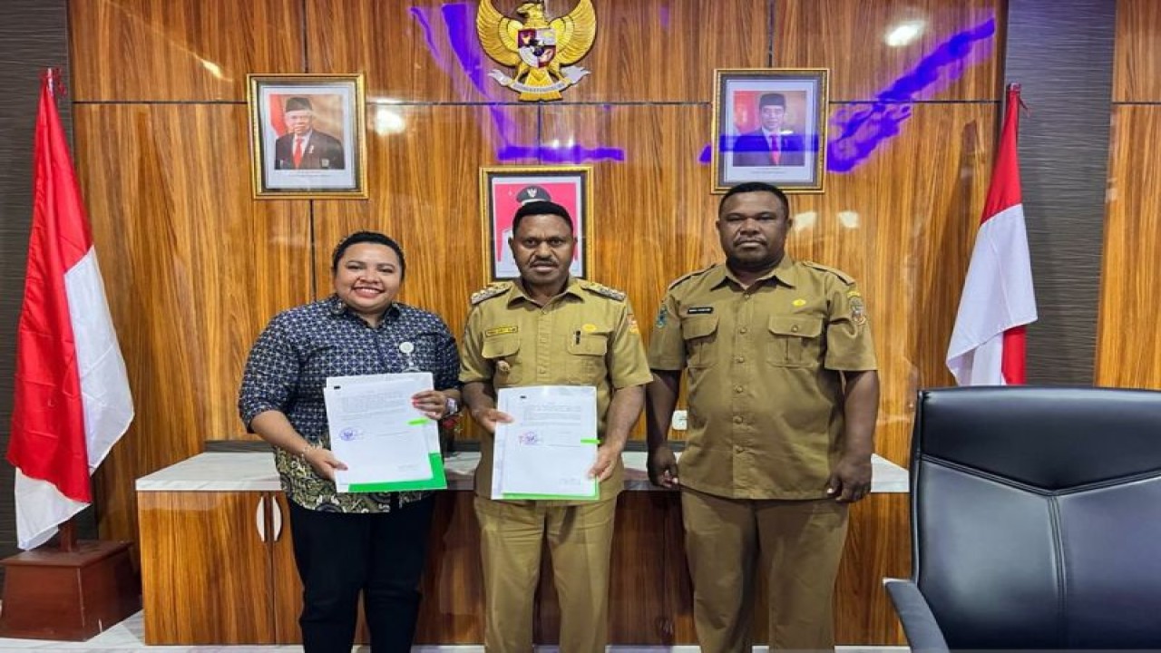 Kepala BPJS Kesehatan Pegunungan Arfak, Rosani Yarangga dan Bupati Pegunungan Arfak, Yosias Saroy menunjukkan lembar rencana kerja UHC tahun 2023, Selasa (20/12/2022). ANTARA/Rachmat Julaini