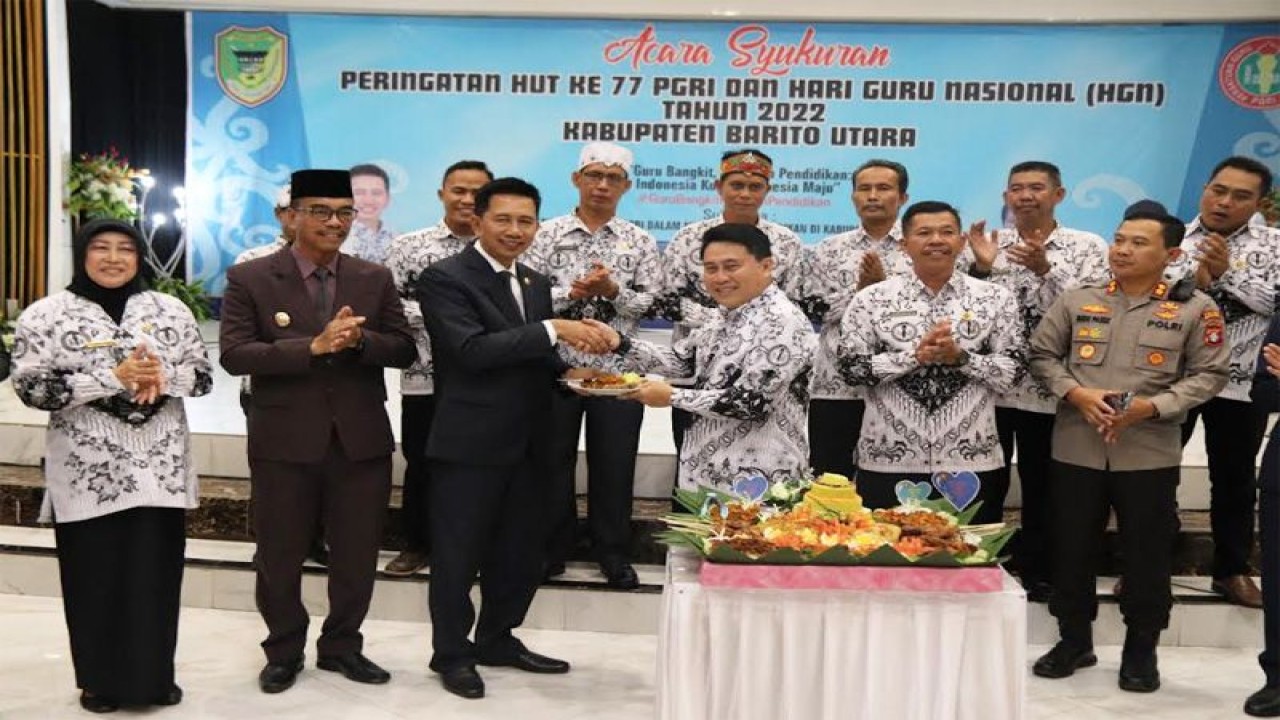 Kepala Dinas Pendidikan Barito Utara Ardian menyerahkan potongan nasi tumpeng kepada Bupati Barito Utara Nadalsyah (ketiga kanan) pada acara perayaan ulang tahun ke-77 PGRI dan Hari Guru Nasional 2022 di Muara Teweh, Selasa (13/12/2022). (ANTARA/HO-Prokopim Barito Utara)
