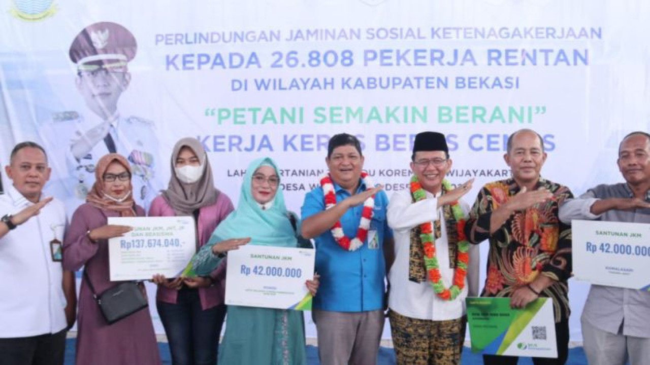 Penyerahan simbolis kartu kepesertaan BPJAMSOSTEK kepada perwakilan kelompok petani di Kawasan Food Estate Kodam Jaya di Kabupaten Bekasi, Jabar, Jumat (9/12/2022). (FOTO ANTARA/Pradita Kurniawan Syah).