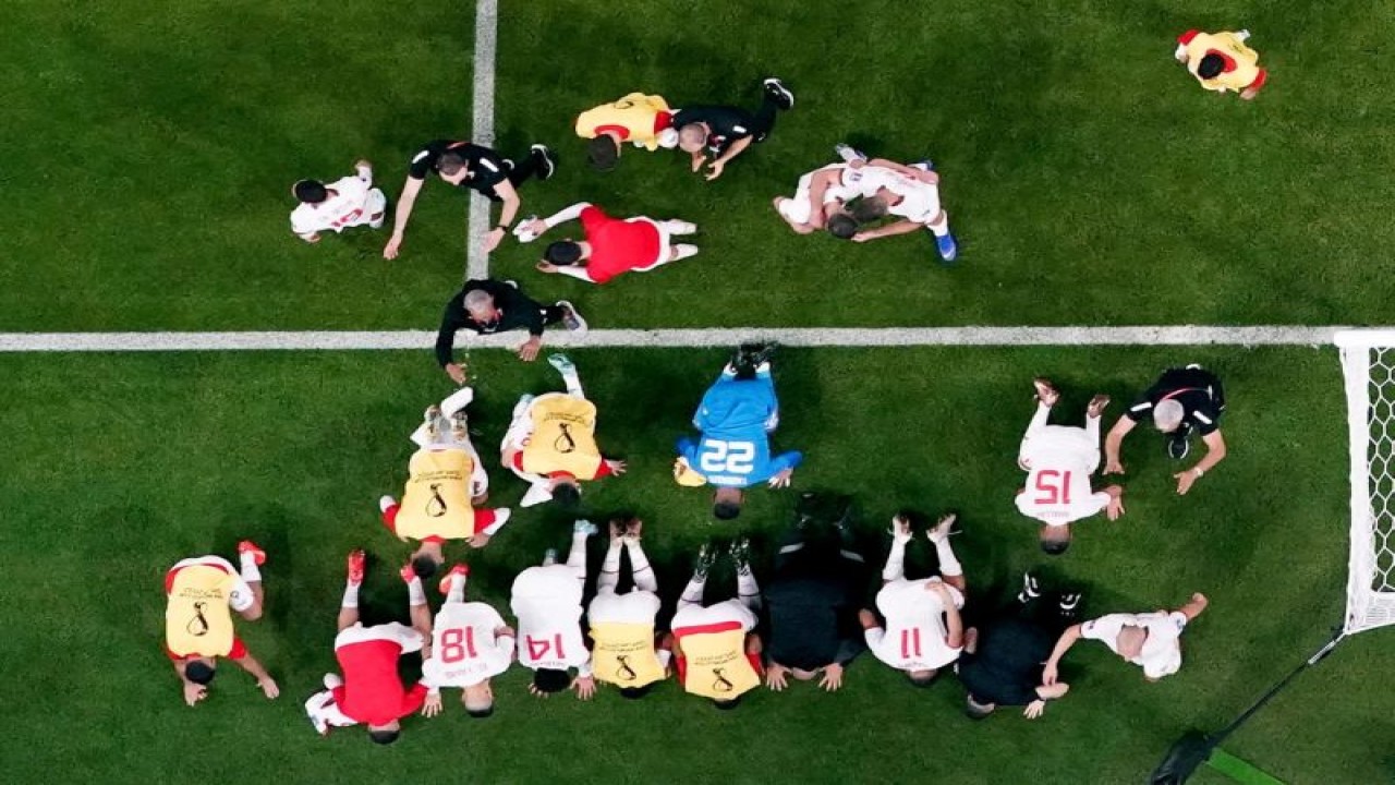 Para pemain Maroko bersujud mensyukuri sukses lolos ke 16 besar setelah menaklukkan Kanada 2-1 dalam pertandingan terakhir Grup F di Stadion Al Thumama, Doha, Qatar, 1 Desember 2022. (REUTERS/HANNAH MCKAY)