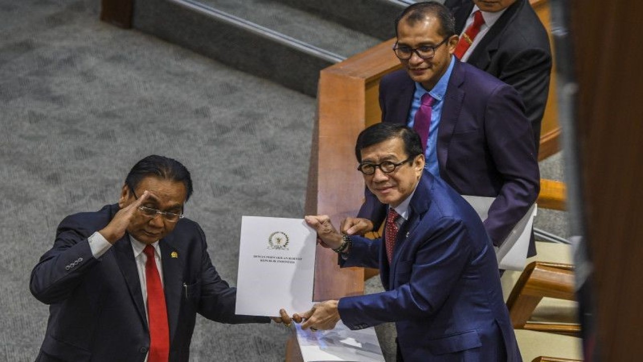 Menteri Hukum dan Hak Asasi Manusia Yasonna H Laoly (kedua kanan) dan Wakil Menteri Hukum dan HAM Edward Omar Sharif Hiariej (kanan) menerima dokumen laporan Komisi III terkait RKUHP dari Ketua Komisi III Bambang Wuryanto (kiri) saat Rapat Paripurna DPR ke-11 masa persidangan II tahun 2022-2023 di Kompleks Parlemen, Senayan, Jakarta, Selasa (6/12/2022). (ANTARA FOTO/GALIH PRADIPTA)