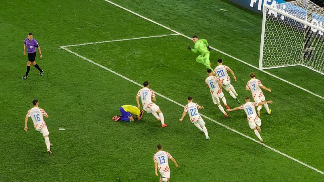 Para pemain tim nasional Kroasia tampak mengejar penjaga gawang Dominik Livakovic (baju hijau) selepas mereka memenangi adu penalti melawan Brazil dalam laga perempat final Piala Dunia 2022 di Stadion Education City, Al Rayyan, Qatar, Jumat (9/12/2022). (ANTARA/Gilang Galiartha)
