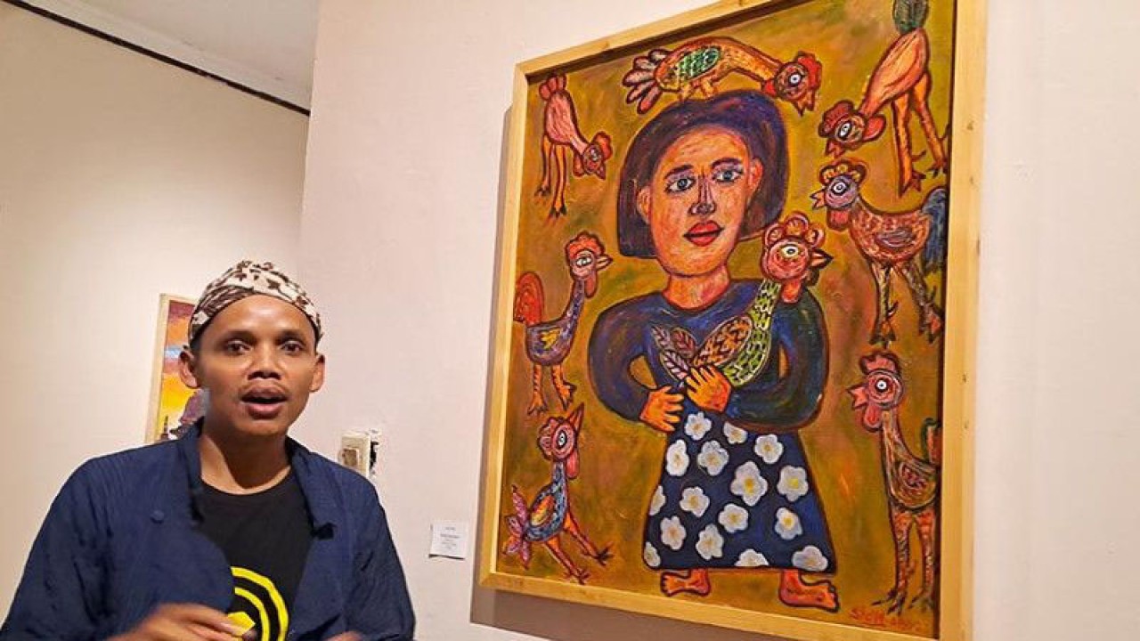 Seniman muda Komunitas Seniman Borobudur Indonesia (KSBI) Nursidiq Abundance menjelaskan pesan makna karyanya, "Ibu dan Sang Jagoan", pada pameran lukisan di Limanjawi Art House Borobudur, Kabupaten Magelang, Jawa Tengah, Minggu (18/12/2022). ANTARA/Hari Atmoko