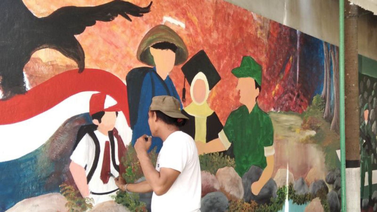 Seorang pelukis tengah menyelesaikan lukisan muralnya di dinding kantor Koramil 01/Kota Kudus, Jawa Tengah, Kamis (15/12/2022). (FOTO ANTARA/Akhmad Nazaruddin Lathif)