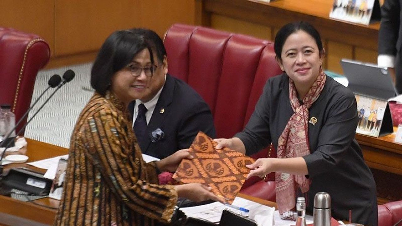 Menteri Keuangan Sri Mulyani Indrawati (kiri) menyerahkan berkas pendapat akhir presiden terkait pembahasan Rancangan Undang-Undang (RUU) tentang Pengembangan dan Penguatan Sektor Keuangan (PPSK) kepada Ketua DPR Puan Maharani yang kemudian disahkan pada rapat paripurna di Kompleks Parlemen, Senayan, Jakarta. ANTARA FOTO/Hafidz Mubarak A/foc/aa.