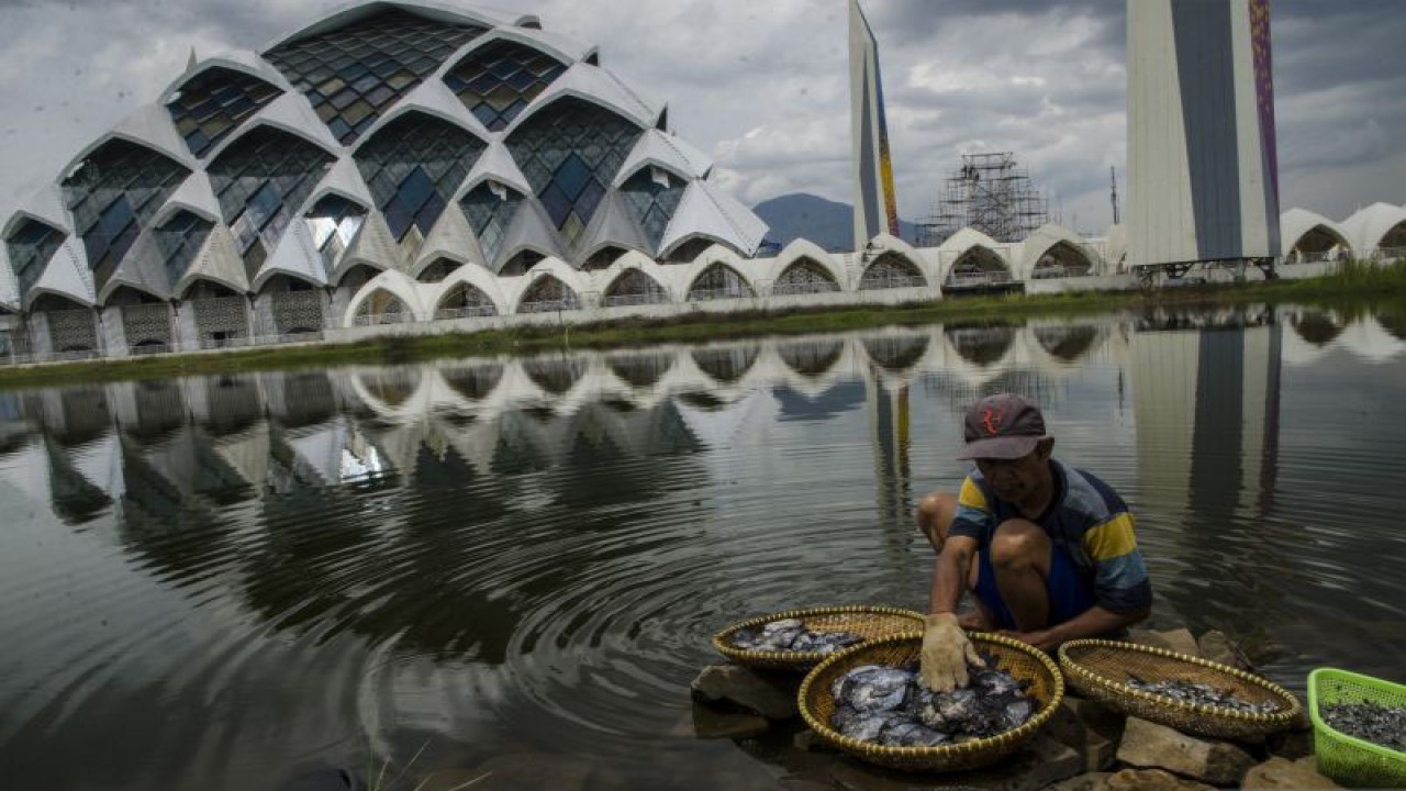 Arsip Foto. Warga mencuci ikan di danau di kompleks Masjid Raya Al Jabbar di Gedebage, Kota Bandung, Provinsi Jawa Barat, Kamis (27/10/2022). Masjid tersebut telah selesai dibangun dan diresmikan pada Jumat (30/12/2022). (ANTARA FOTO/NOVRIAN ARBI)