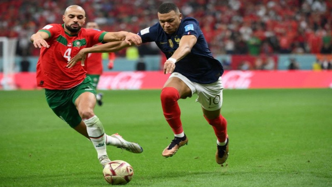 Gelandang Maroko Sofyan Amrabat berduel dengan striker Prancis Kylian Mbappe dalam semifinal Piala Dunia 2022 antara Prancis dan Maroko di Stadion Al-Bayt di Al Khor di sebelah utara Doha, Qatar, 14 Desember 2022. (Photo by FRANCK FIFE / AFP) (AFP/FRANCK FIFE)