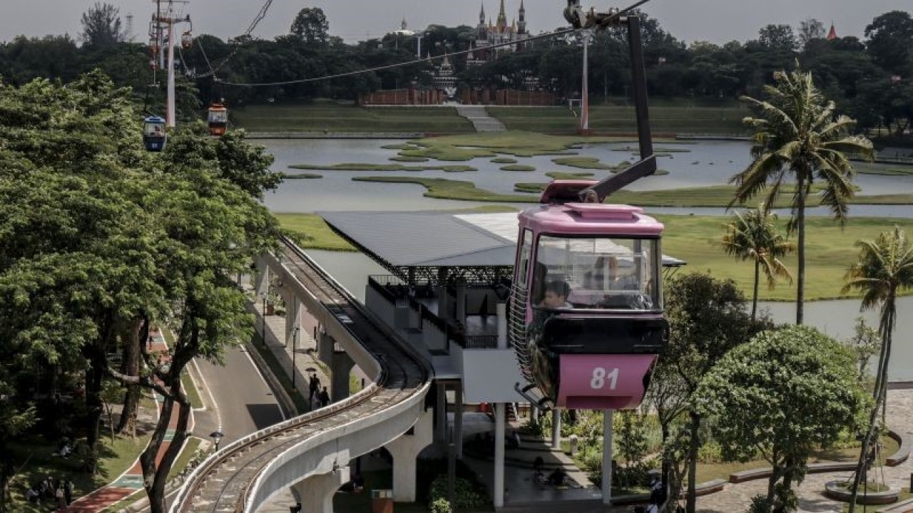 Sejumlah pengunjung menggunakan kereta gantung untuk melihat lanskap pulau Indonesia di Taman Mini Indonesia Indah, Jakarta, Sabtu (17/12/2022). ANTARA FOTO/Darryl Ramadhan/hp. (ANTARA FOTO/DARRYL RAMADHAN)