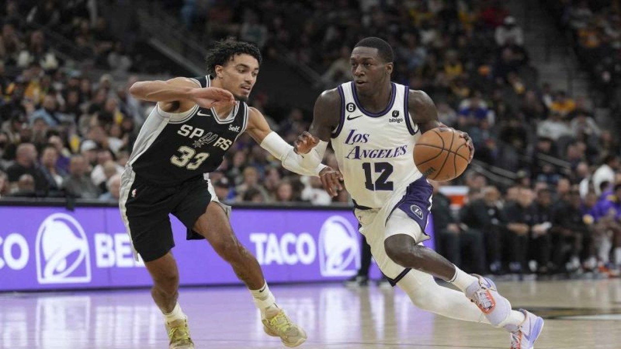 Pemain Los Angeles Lakers Kendrick Nunn (12) berusaha melewati hadangan pemain San Antonio Spurs Tre Jones (33) pada pertandingan bola basket Liga NBA di AT&T Center, San Antonio, Texas, Amerika Serikat, Sabtu (26/11/2022). Spurs kalah dari tamunya Lakers 138-143. ANTARA FOTO/USA TODAY Sports/Daniel Dunn/wsj.