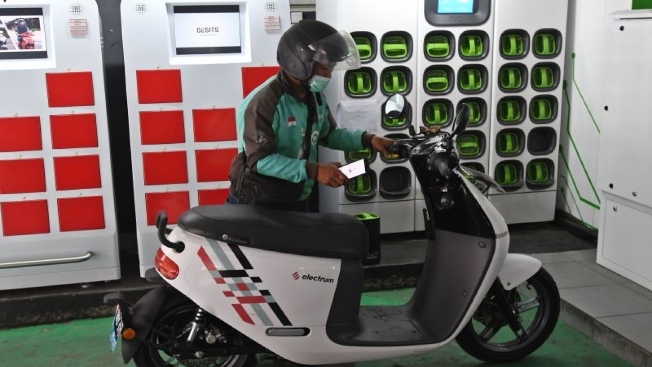 Pengemudi ojek daring mengganti baterai sepeda motor listriknya di stasiun pengisian baterai listrik di Kuningan, Jakarta, Senin (30/5/2022). Berdasarkan data Kementerian Perhubungan per Maret 2022, jumlah kendaraan bermotor listrik berbasis baterai (KBLBB) di Indonesia mencapai 16.060 unit atau naik 74 persen dari jumlah pada Agustus 2021 yang mencapai 9.192 unit, sementara jumlah stasiun pengisian baterai listrik per Februari 2022 mencapai 267 unit di 195 titik se-Indonesia. ANTARA FOTO/Aditya Pradana Putra/aww.