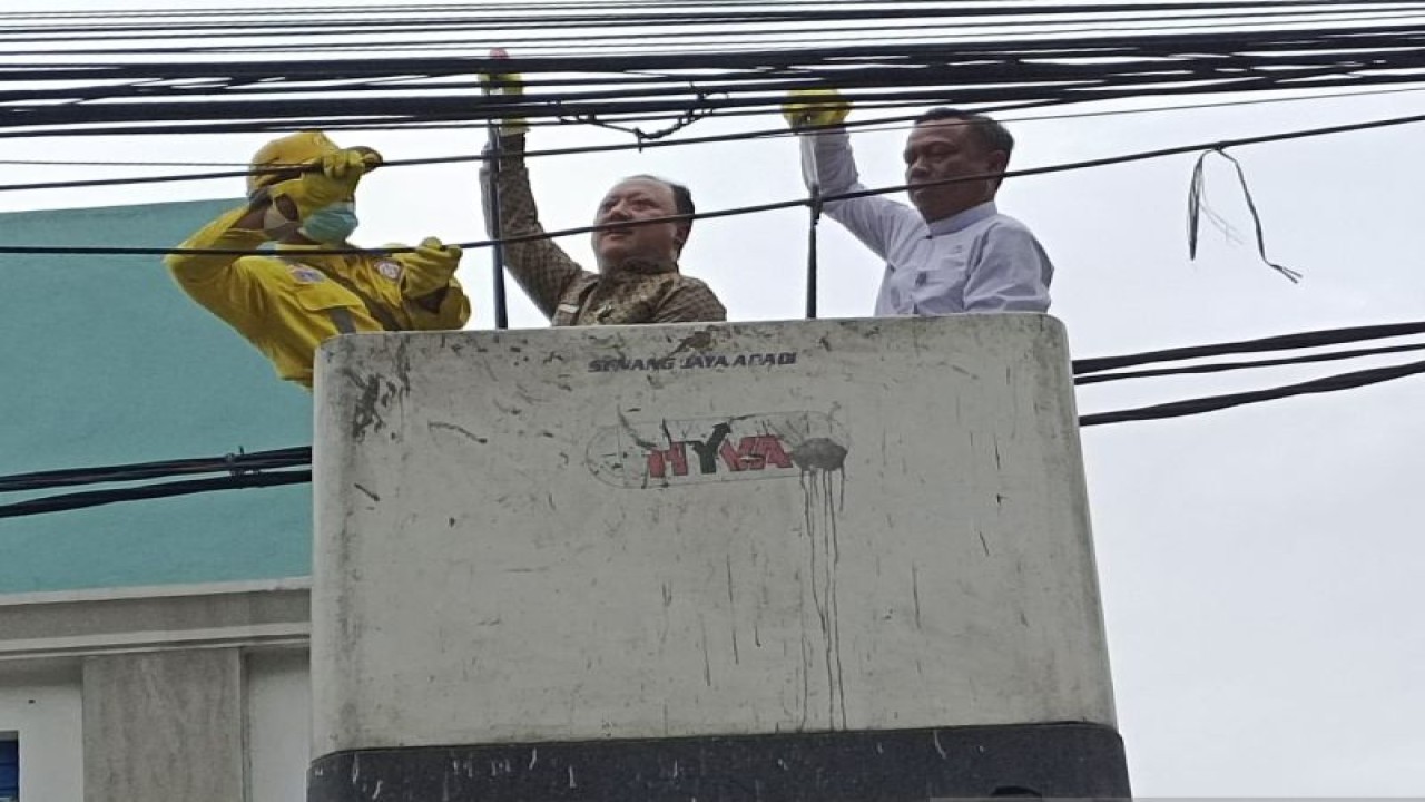 Wali Kota Jakarta Selatan Munjirin (baju putih) bersiap memotong kabel udara di Jalan Tebet Timur, Tebet, Jakarta Selatan, Jumat (30/12/2022). ANTARA/Yoanita HD