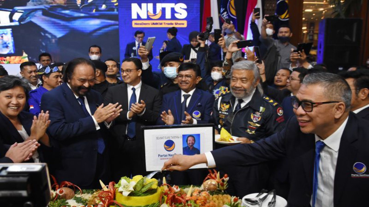 Ketua Umum Partai NasDem Surya Paloh (kedua kiri) didampingi Wakil Ketua Umum Partai NasDem Ahmad Ali (kanan), Sekjen Johnny G. Plate (ketiga kanan), dan bakal calon presiden dari Partai NasDem Anies Baswedan (ketiga kiri) memotong tumpeng dalam Perayaan HUT ke-11 Partai NasDem di Jakarta, Jumat (11/11/2022). . ANTARA FOTO/Indrianto Eko Suwarso/YU