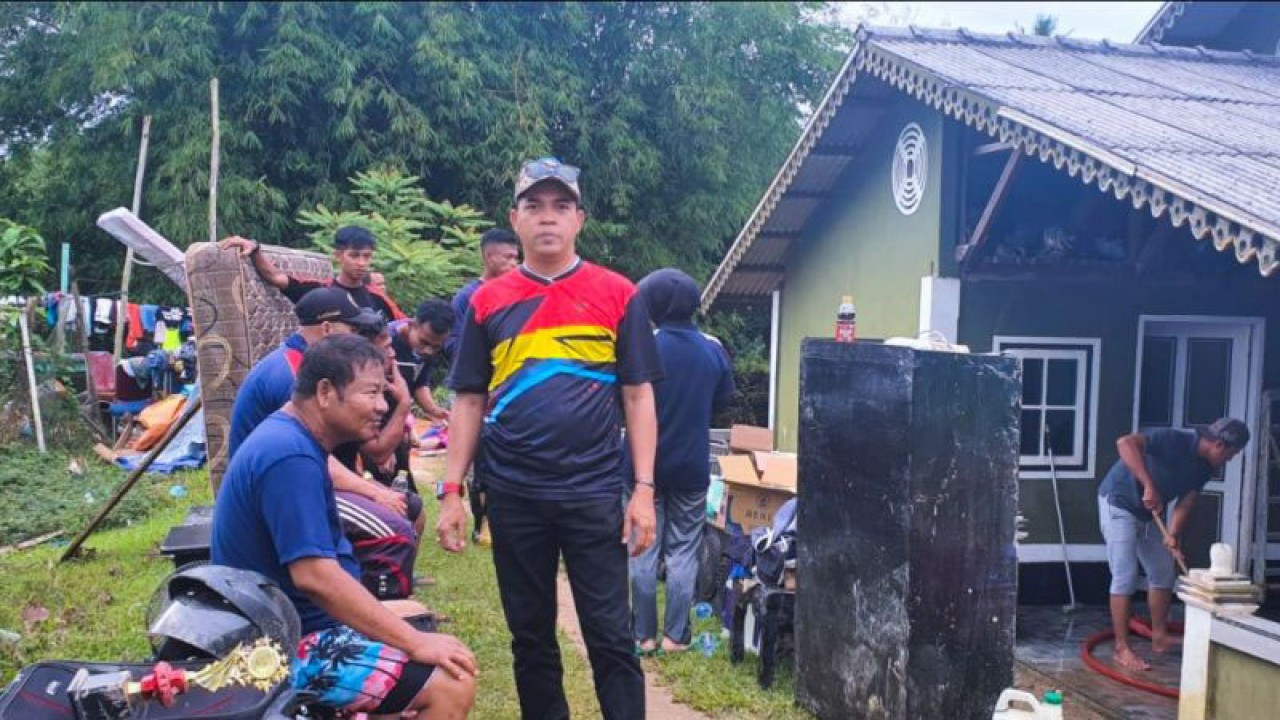 Sejumlah orang di dekat salah satu rumah warga di Jalan Sudirman Ranai, Natuna, Kepri terdampak banjir yang dibersihkan secara gotong royong, Jumat (16/12/2022). (ANTARA/Cherman)