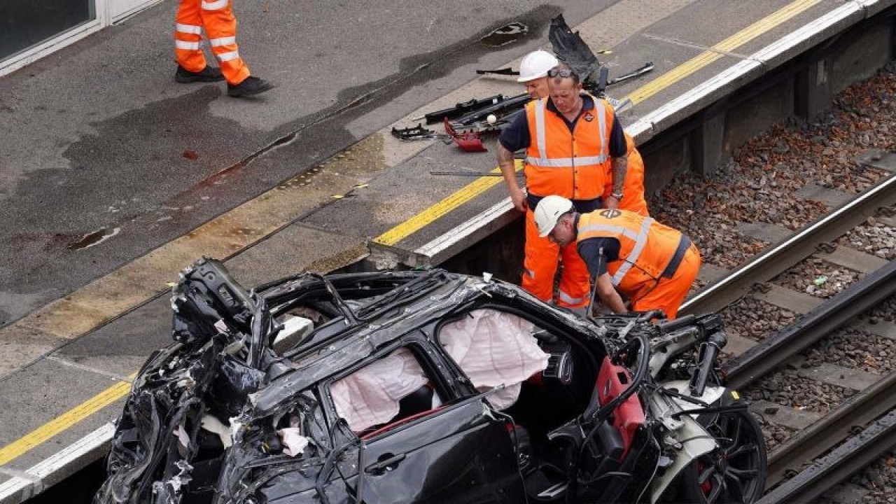 Petugas mengevakuasi sebuah mobil di lokasi kecelakaan Range Rover membelok dari jalan ke jalur kereta Piccadilly Line setelah bertabrakan dengan Tesla, di Stasiun Park Royal di London Barat, Inggris (22/8/2022). ANTARA FOTO/ANTARA FOTO/REUTERS/Maja Smiejkowska/aww.