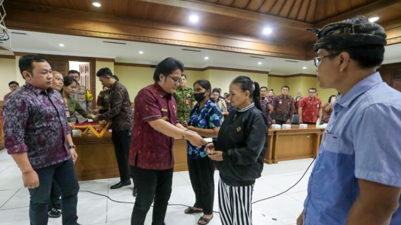 Bupati Badung Nyoman Giri Prasta menyerahkan bantuan dana kepada masyarakat yang menjadi korban bencana di Kabupaten Badung Tahun 2022. ANTARA/HO-Pemkab Badung
