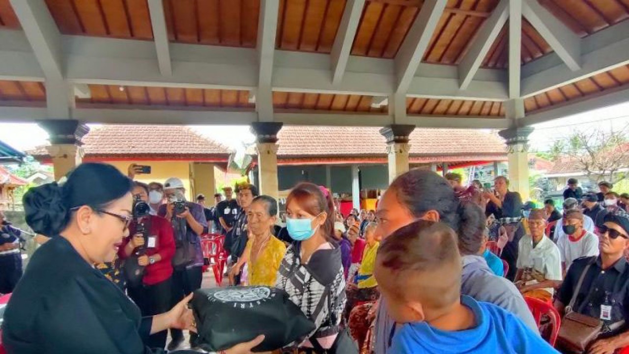 Manggala Utama (Ketua Umum) Pakis Bali Putri Suastini Koster saat menyerahkan bantuan bahan pokok pada acara Tresna lan Punia di Klungkung, Sabtu (17/12/2022). ANTARA/Ni Luh Rhismawati.