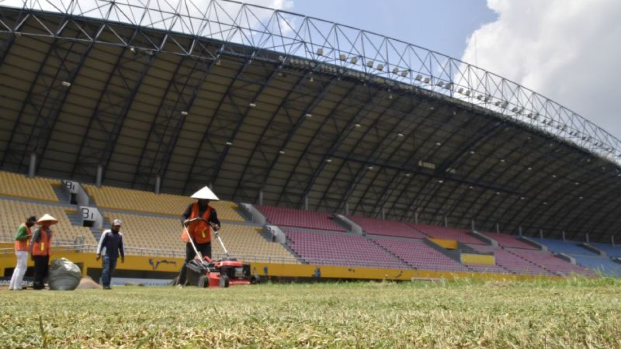 Petugas melakukan perawatan rumput di Stadion Glora Sriwijaya, Jakabaring, Palembang, Sumatera Selatan (ANTARA/M Riezko Bima Elko P)