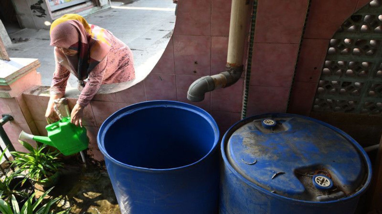 Warga memanfaatkan air bersih dari Perumda Perusahaan Air Minum (PAM) Jaya untuk menyiram tanaman hiasnya di RW 01, Kamal Muara, Jakarta, Selasa (23/8/2022). Mulai 2022 ini warga di Kelurahan Kamal Muara telah mendapatkan layanan jaringan pipa air bersih melalui program Sistem Penyediaan Air Minum (SPAM) Hutan Kota yang menargetkan 30.000 sambungan pelanggan baru di empat wilayah di ujung Jakarta, yakni Kamal Muara, Kamal, Tegal Alur dan Pegadungan. ANTARA FOTO/Aditya Pradana Putra/hp.