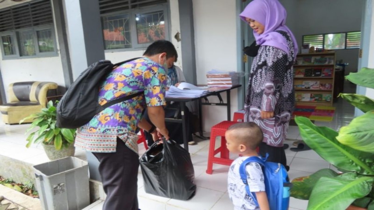 Seorang guru pendidikan anak usia dini Kota Pekalongan mendatangi rumah anak PAUD untuk menyerahkan bantuan dari Kemensos berupa alat tulis kantor, Selasa (27/12/2022). ANTARA/HO-Humas Kota Pekalongan