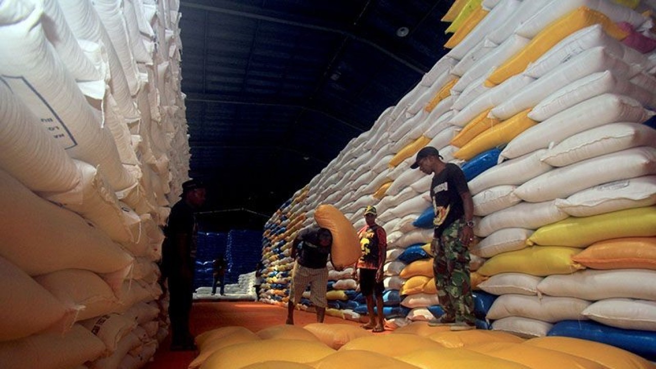 Pekerja mengangkat beras di Gudang Bulog Santorosa, Jayapura, Papua, Jumat (2/12/2022). ANTARA FOTO/Gusti Tanati/app/aww/pri.