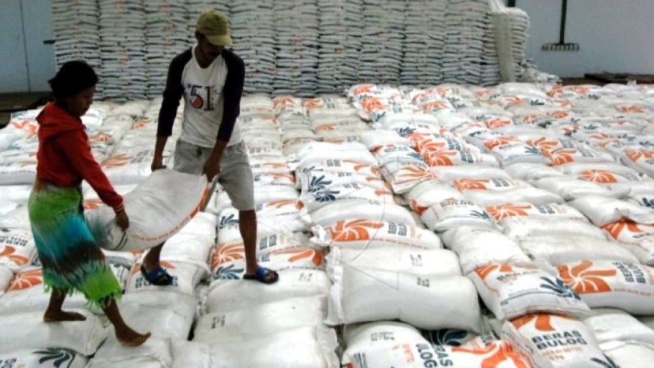 Pekerja mengangkat karung isi beras di Gudang Beras Bulog Divre Sulselbar Makassar, Sulawesi Selatan. ANTARA FOTO/Abriawan Abhe.