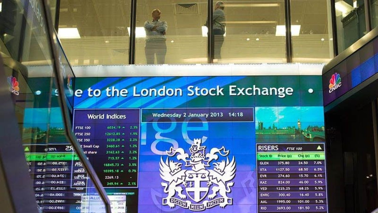 Pekerja terlihat berbincang di atas papan elektronik pergerakan saham di London Stock Exchange, Inggris. REUTERS/Paul Hackett/aa.