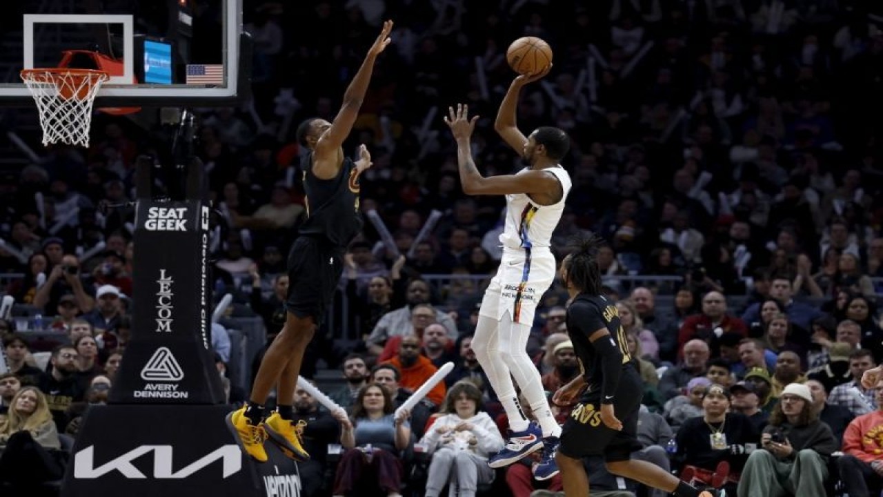 Pemain Brooklyn Nets Kevin Durant memasukkan bola di tengah hadangan pemain Cleveland Cavaliers Evan Mobley dalam laga NBA antara Nets dan Cavaliers di Rocket Mortgage Fieldhouse, Cleveland, Ohio, pada 26 Desember 2022. (Getty Images via AFP/KIRK IRWIN)