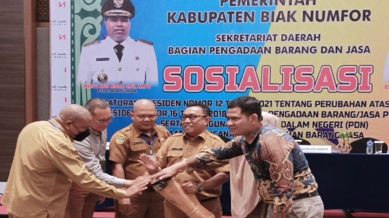 Pelaksana tugas Sekda Biak ZR Mailoa MM (tengah) menabuh tifa bersama membuka sosialisasi Perpres No 12 Tahun 2021 tentang pengadaan barang dan jasa pemerintah, Senin ( 12/12). ANTARA/Muhsidin