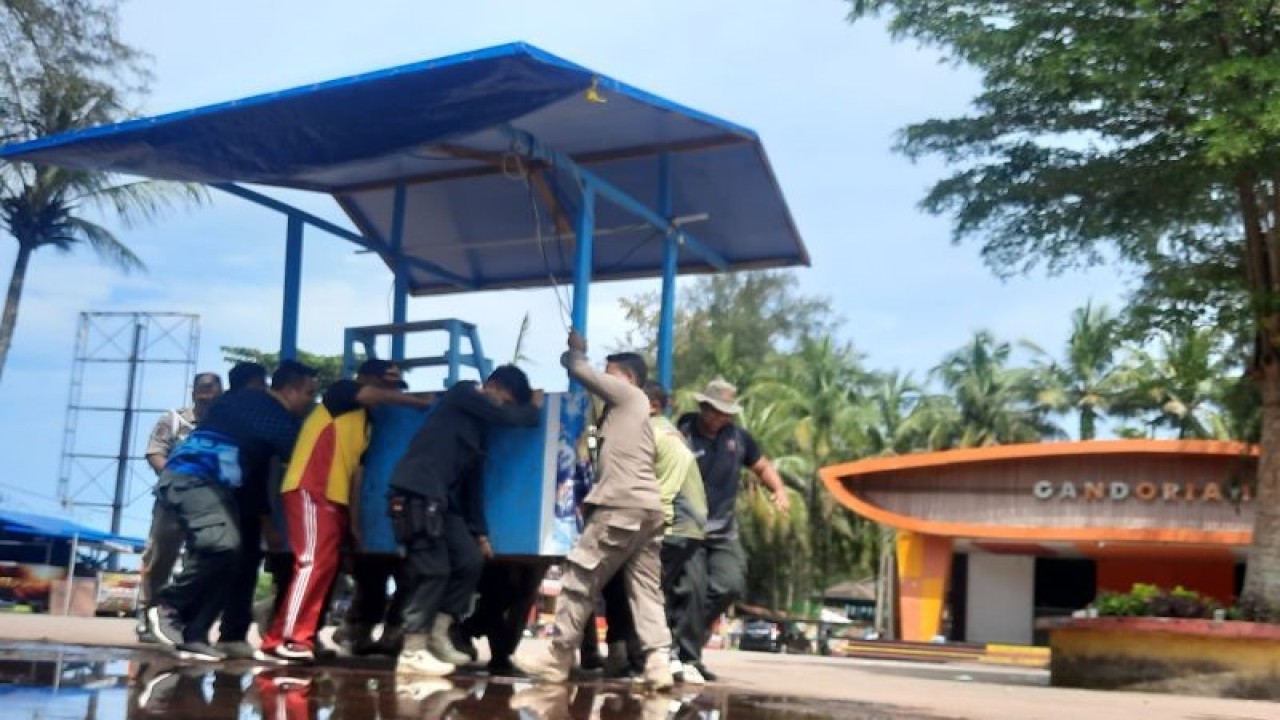 Anggota Satpol PP Pariaman, Sumbar mengangkat meja pedagang di kawasan ruang terbuka atau pelataran pentas seni Pantai Gandoriah pada Jumat (23/12) pagi. ANTARA/Aadiaat M. S.