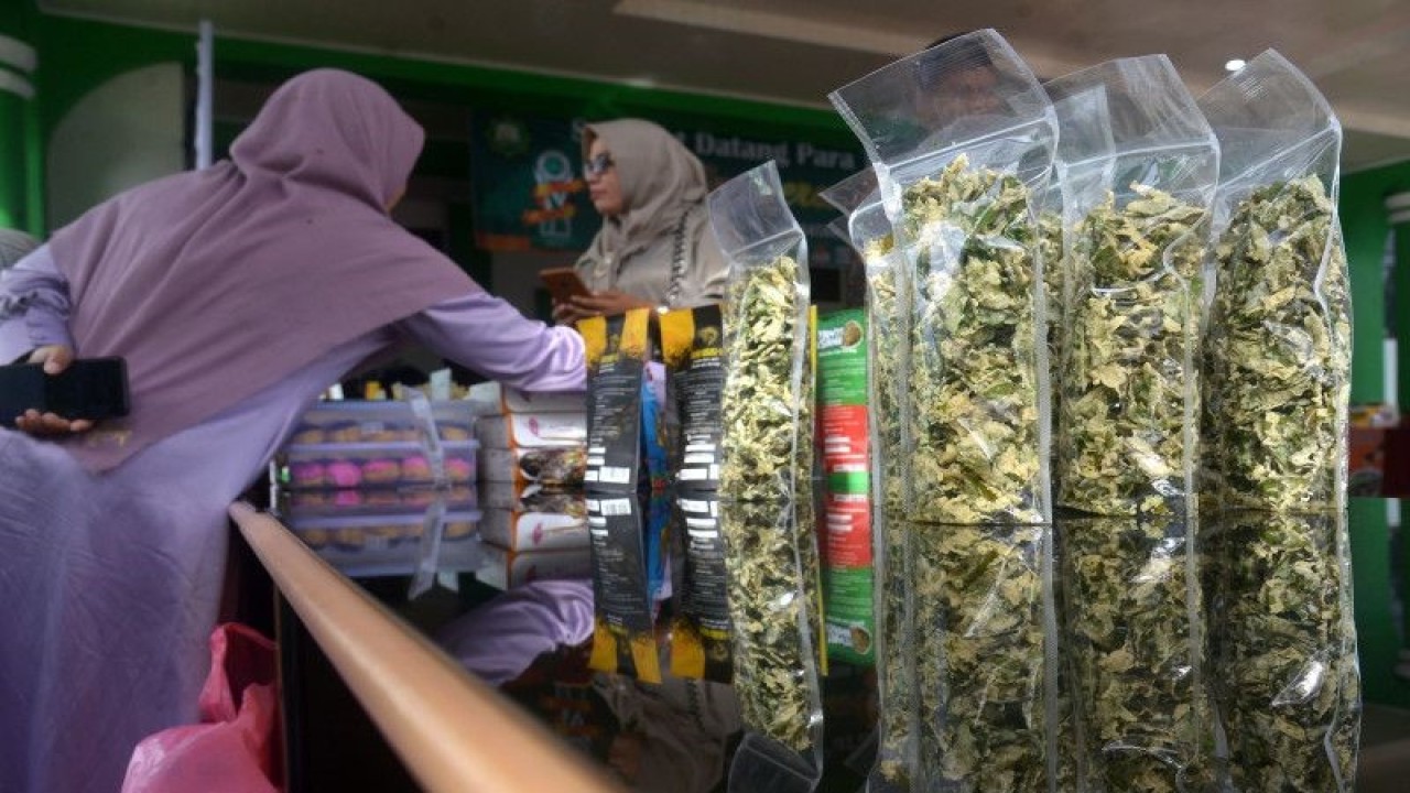 Pelaku usaha menata produk Usaha Mikro Kecil dan Menengah (UMKM) saat pameran produk halal pada kegiatan Anugerah Halal di Majelis Permusyawaratan Ulama (MPU) Aceh, Kabupaten Aceh Besar, Aceh, Senin (5/12/2022). ANTARA FOTO/Ampelsa/nym.