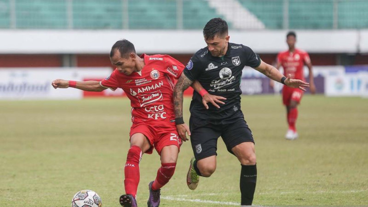 Pesepak bola Persija Jakarta Riko Simanjuntak (kiri) berebut bola dengan pesepak bola Persebaya Surabaya Higor Vidal (kanan) pada pertandingan Liga 1 di Stadion Maguwoharjo, Sleman, DI Yogyakarta, Jumat (16/12/2022). Pertandingan tersebut berakhir imbang dengan skor 1-1. ANTARA FOTO/Hendra Nurdiyansyah/aww.