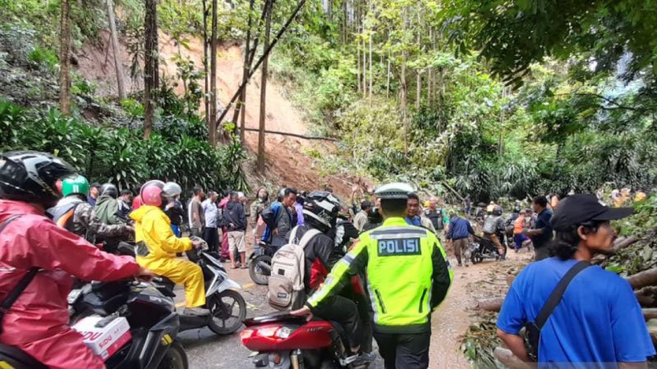 Personel Satlantas Polres Sukabumi saat mengatur arus kendaraan dari arah Sukabumi menuju Palabuhanratu yang terjebak akibat longsor menutup akses jalan tepatnya di Jalan Nasional II di Kampung Pasirsuren, Desa Tonjong, Kecamatan Palabuhanratu, Kabupaten Sukabumi, Jabar pada Selasa, (13/12). Antara/Aditya Rohman