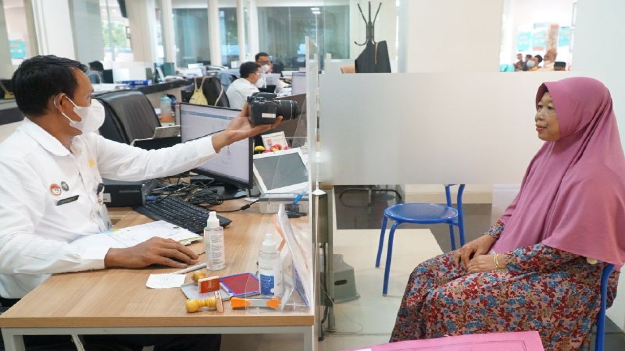 Petugas Imigrasi Kediri mengambil foto warga saat pengurusan paspor di Kediri, Jawa Timur. ANTARA/HO-Imigrasi Kediri