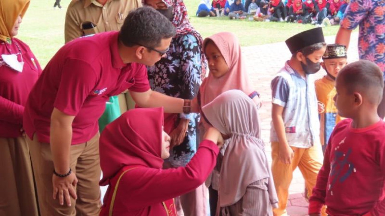 Ketua Tim Penggerak PKK Kota Pekalongan Inggit Soraya didampingi Wali kota Pekalongan Afzan Arslan Djunaid sedang membagikan paket sembako pada seorang anak yatim, Senin (19/12/2022). (ANTARA/Kutnadi)