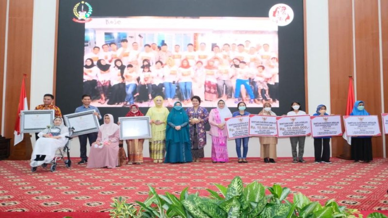 Ketua PKK Sulsel Naoemi Octarina (berbaju biru) berfoto bersama usai penyerahan bantuan dan penghargaan di Peringatan Hari Ibu 2022. ANTARA/HO-Pemprov Sulsel