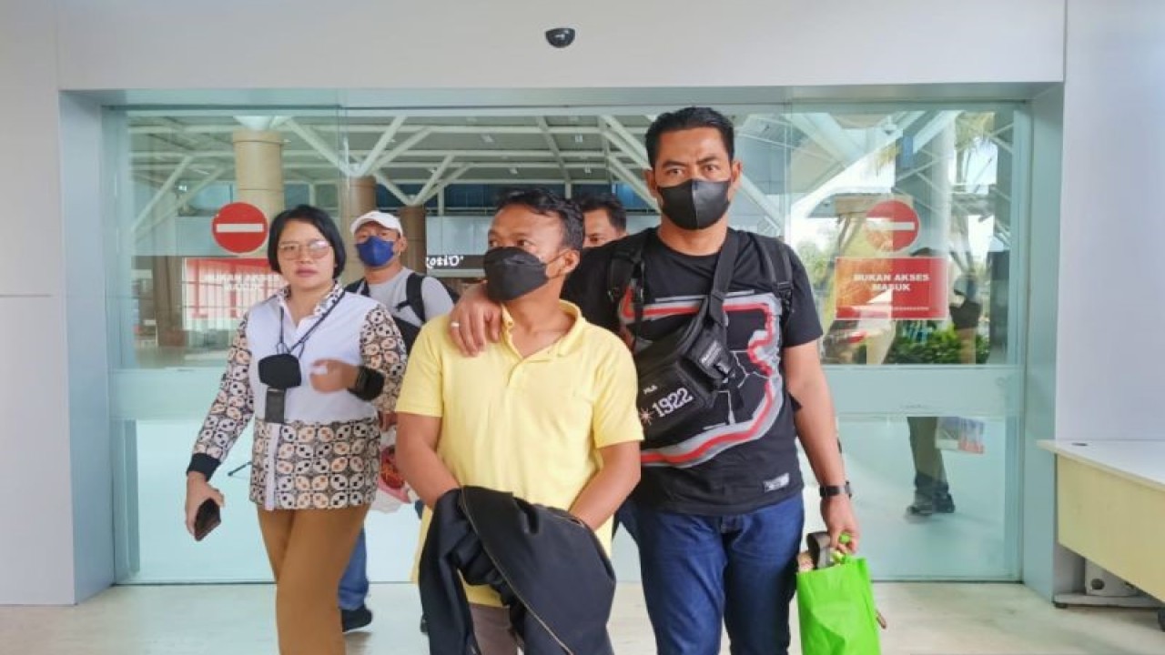Polisi mengawal tersangka perekrut PMI usia anak berinisial IS (tengah) asal Jakarta, setibanya di Bandara International Zainuddin Abdul Madjid, NTB, Jumat (9/12/2022). ANTARA/HO-Polda NTB