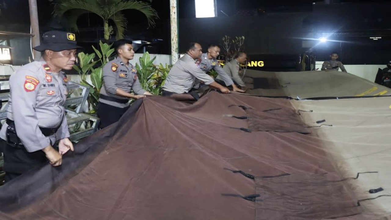 Personel Polres Malang pada saat menyiapkan tenda untuk membuka Posko Siaga Bencana Gunung Semeru, di Kepolisian Sektor (Polsek) Ampelgading, di Kabupaten Malang, Jawa Timur, Minggu malam (4/12/2022). (ANTARA/HO-Humas Polres Malang)