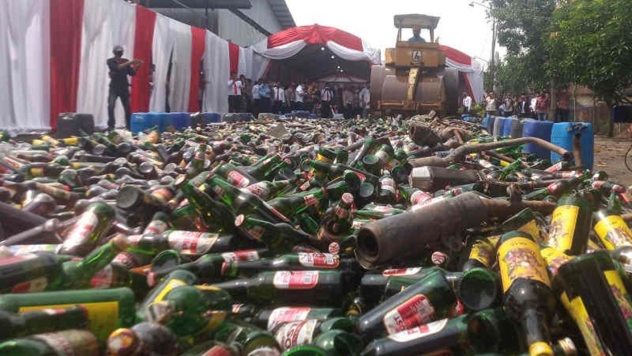 Petugas memusnahkan minuman keras dan kenalpot dengan cara dilindas menggunakan setum di Indramayu, Jawa Barat, Rabu (28/12/2022). (ANTARA/Khaerul Izan(