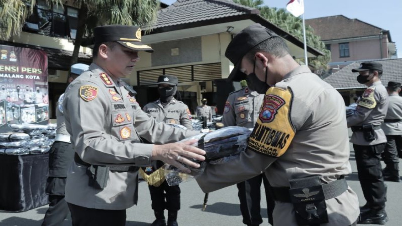 Kapolresta Malang Kota Kombes Pol Budi Hermanto (kiri) secara simbolis menyerahkan peralatan bencana untuk salah satu Bhabinkamtibmas, di Kota Malang, Jawa Timur, Selasa (6/12/2022). (ANTARA/HO-Humas Polresta Malang Kota)