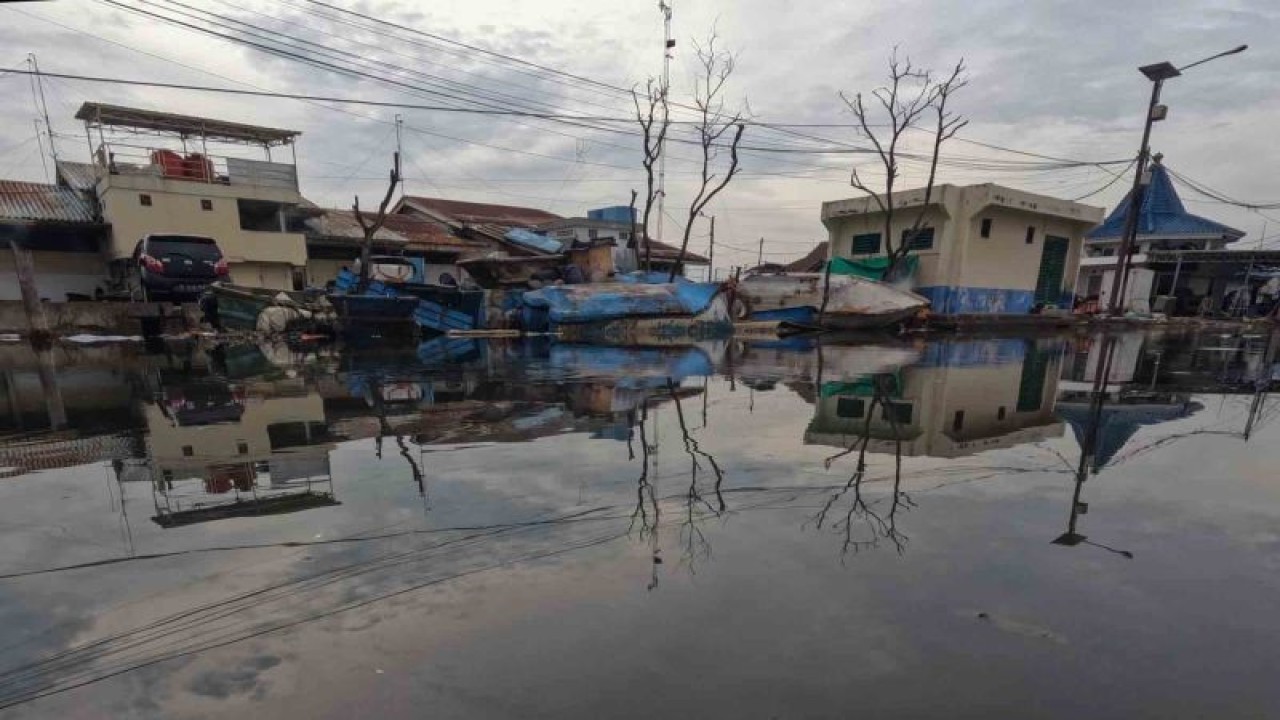Suasana jalan yang terendam limpasan air laut ke daratan atau rob di Pelabuhan Muara Baru Jakarta, Rabu (28/12/2022). ANTARA FOTO/Wahyu Putro A/foc. (ANTARA FOTO/WAHYU PUTRO A)