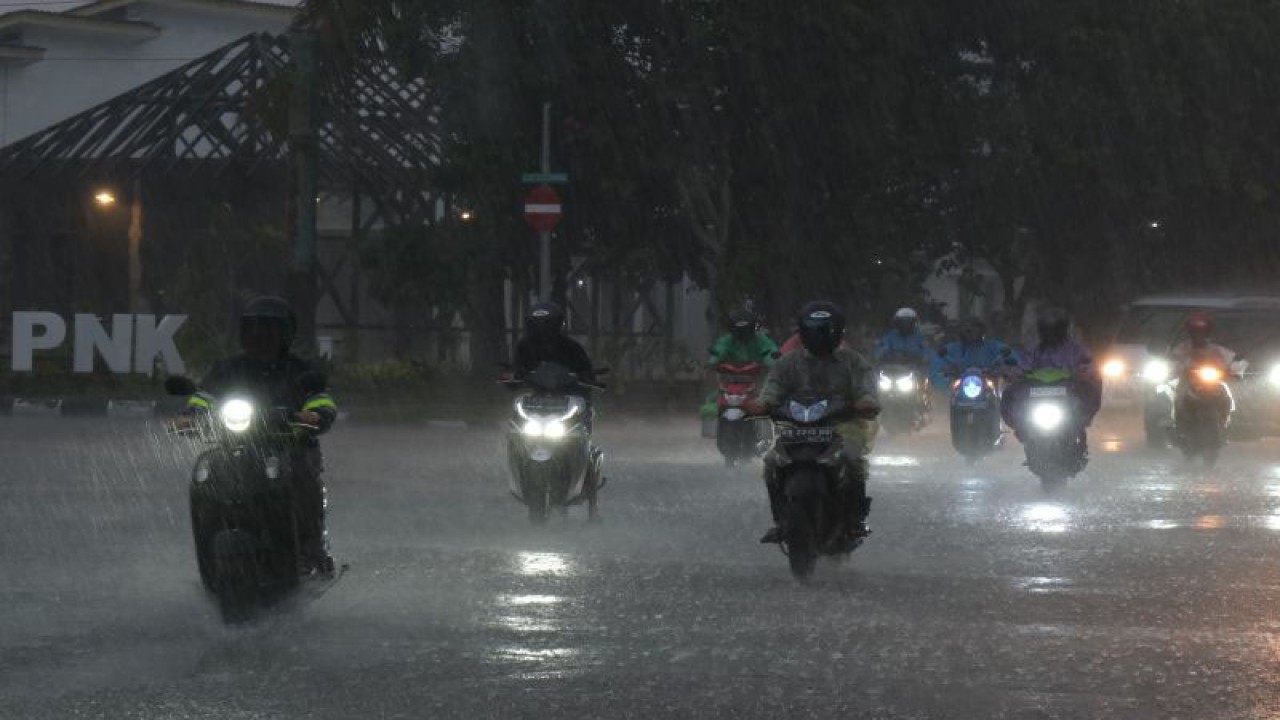 Arsip Foto. Pengendara sepeda motor melaju menerobos hujan di Jalan Ahmad Yani, Kota Pontianak, Provinsi Kalimantan Barat, Rabu (21/12/2022). (ANTARA FOTO/JESSICA HELENA WUYSANG)