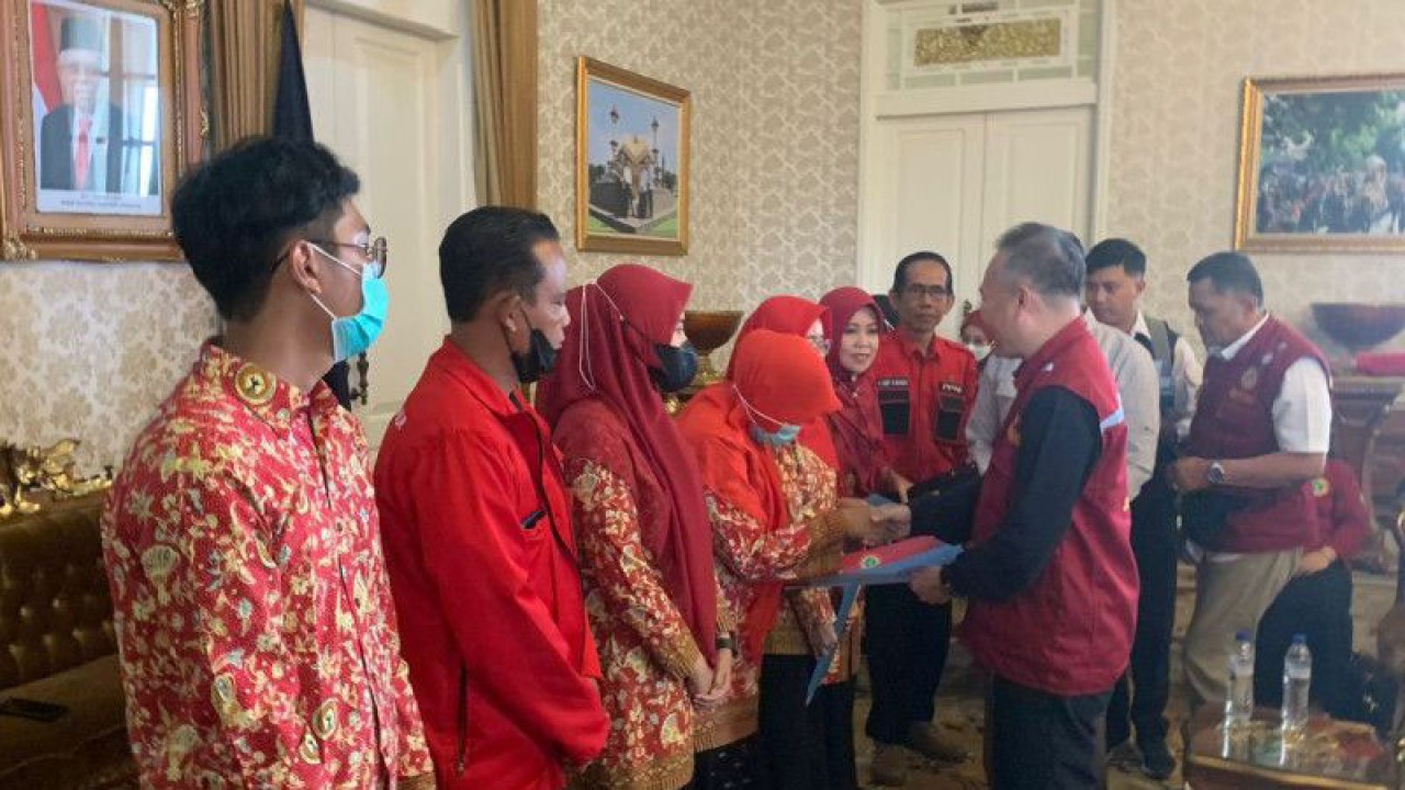 Ketua Dewan Pengurus Wilayah Persatuan Perawat Nasional Indonesia (PPNI) Provinsi Jawa Barat Budiman secara simbolis menyerahkan bantuan kepada perwakilan perawat yang terdampak gempa bumi di Kabupaten Cianjur, Provinsi Jawa Barat, Selasa (6/12/2022). (ANTARA/Ahmad Fikri)