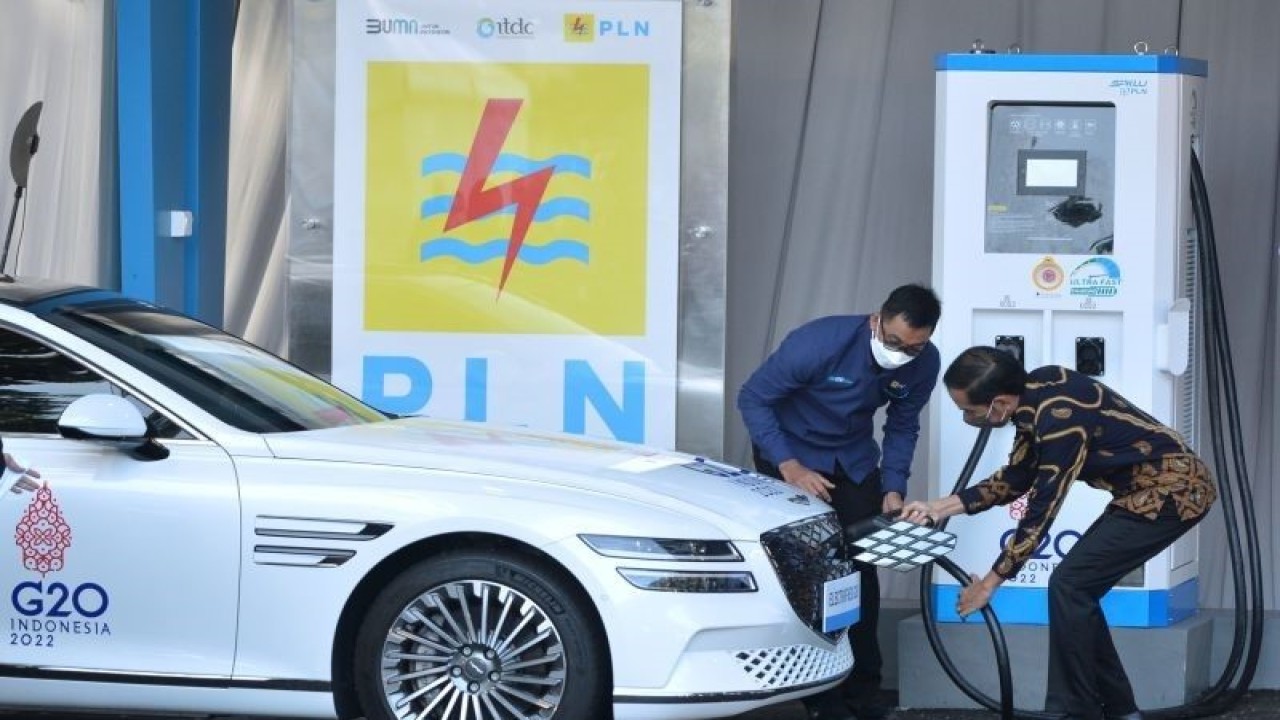 Presiden Joko Widodo (kanan) didampingi Direktur Utama PLN Darmawan Prasodjo (kiri) mengisi daya mobil listrik saat peresmian Stasiun Pengisian Kendaraan Listrik Umum (SPKLU) Ultra Fast Charging di Central Parking Nusa Dua, Badung, Bali. ANTARA FOTO/Fikri Yusuf/aww.