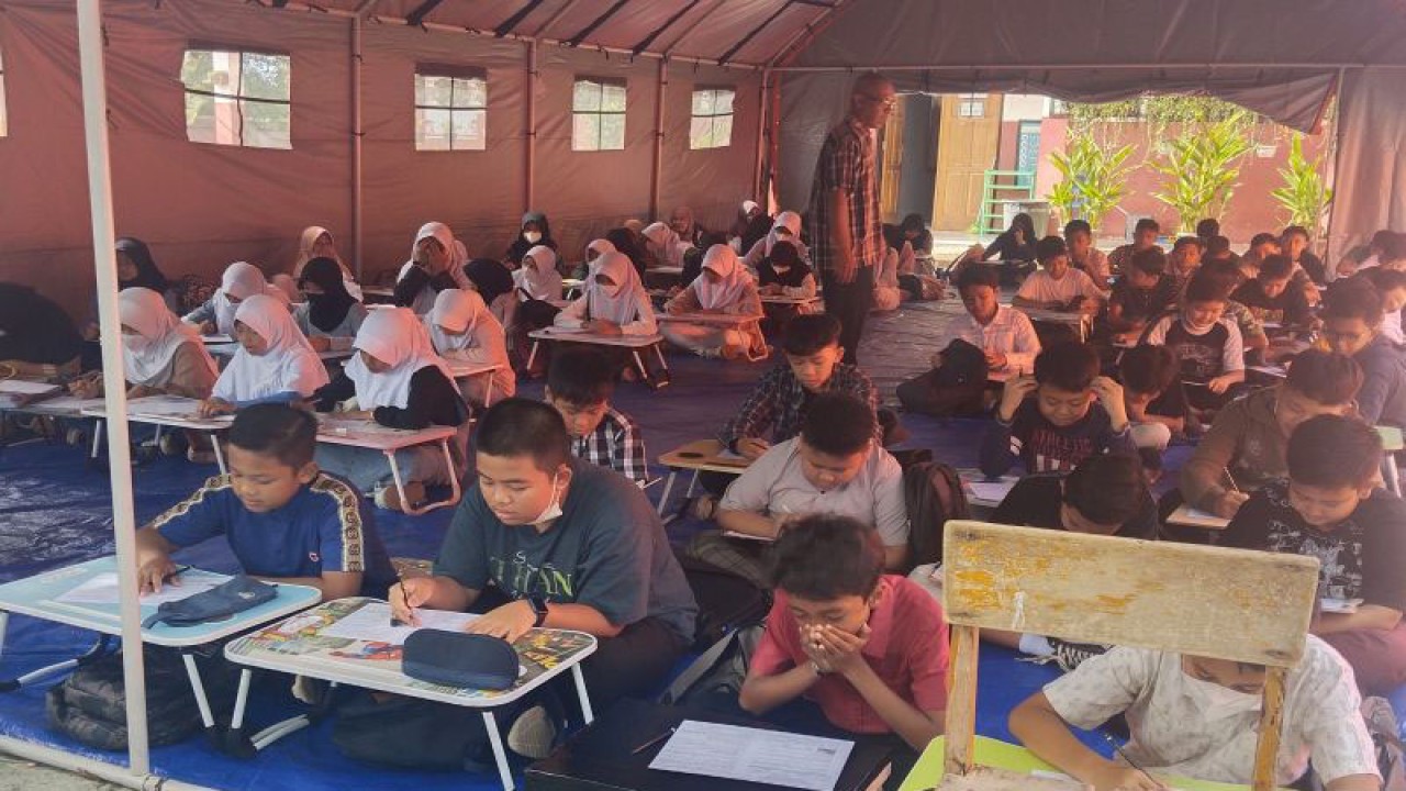 Siswa SDN Ibu Jenab I Cianjur, Jawa Barat, sudah mulai menjalani proses belajar mengajar normal sejak Senin (13/12/2022) di dalam tenda karena ruang kelas mereka rusak akibat gempa.(ANTARA/Ahmad Fikri).
