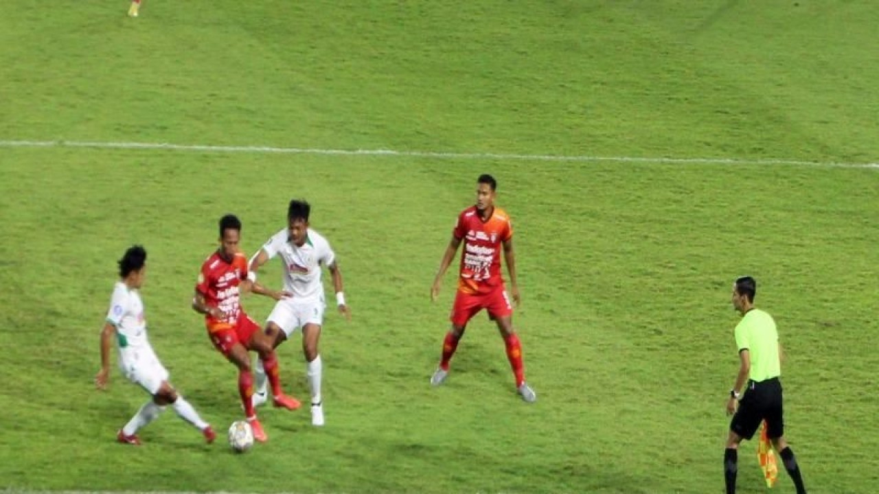 Dua pemain Bali United (kostum merah merah ) saat berebut bola dua pemain PSS Sleman (kostum putih putih) dalam pertandingan Liga 1 2022 di Stadion Manahan Solo, Senin (19/12/2022) malam. ANTARA/Bambang Dwi Marwoto.