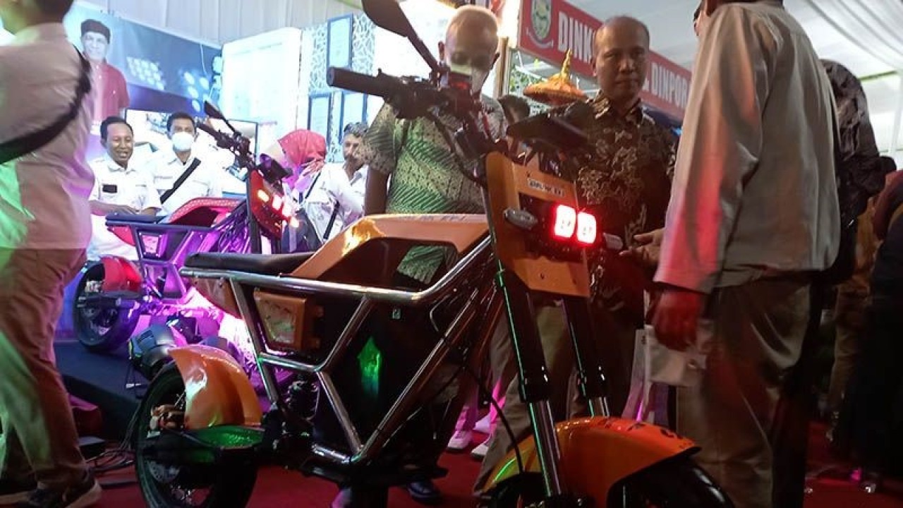 Kepala Dinperindag Kabupaten Purbalingga Johan Arifin (kanan menghadap kamera) sedang menjelaskan kepada pengunjung terkait dengan prototipe sepeda motor listrik Bralink EV-1 yang baru diluncurkan dalam pembukaan Purbalingga Expo 2022 di Kompleks GOR Goentoer Darjono, Purbalingga, Kamis (15/12/2022) malam. ANTARA/Sumarwoto